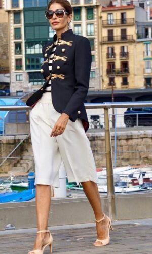 Una mujer vestida con una chaqueta Blazer Panthera y pantalones cortos blancos.