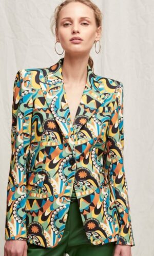 Un modelo usando una chaqueta multicolor abstracta y pantalones verdes.